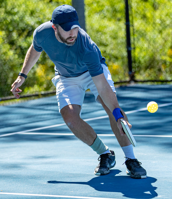 man playing pickleball hitting a ball - Pickelball rules
